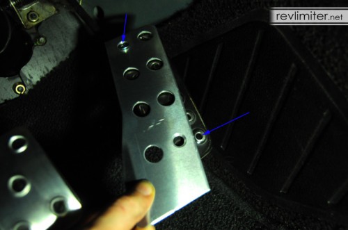 The gas pedal cover uses these two holes (blue arrows).