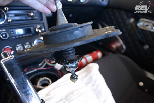 Just lift the whole thing away from the transmission tunnel. Keep a rag handy to catch any drips. 